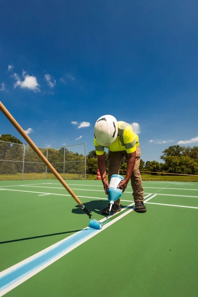 Employee painting lines on a sports court